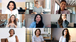 A photo of a computer screen.  Nine diverse women meet together virtually during the coronavirus pandemic.